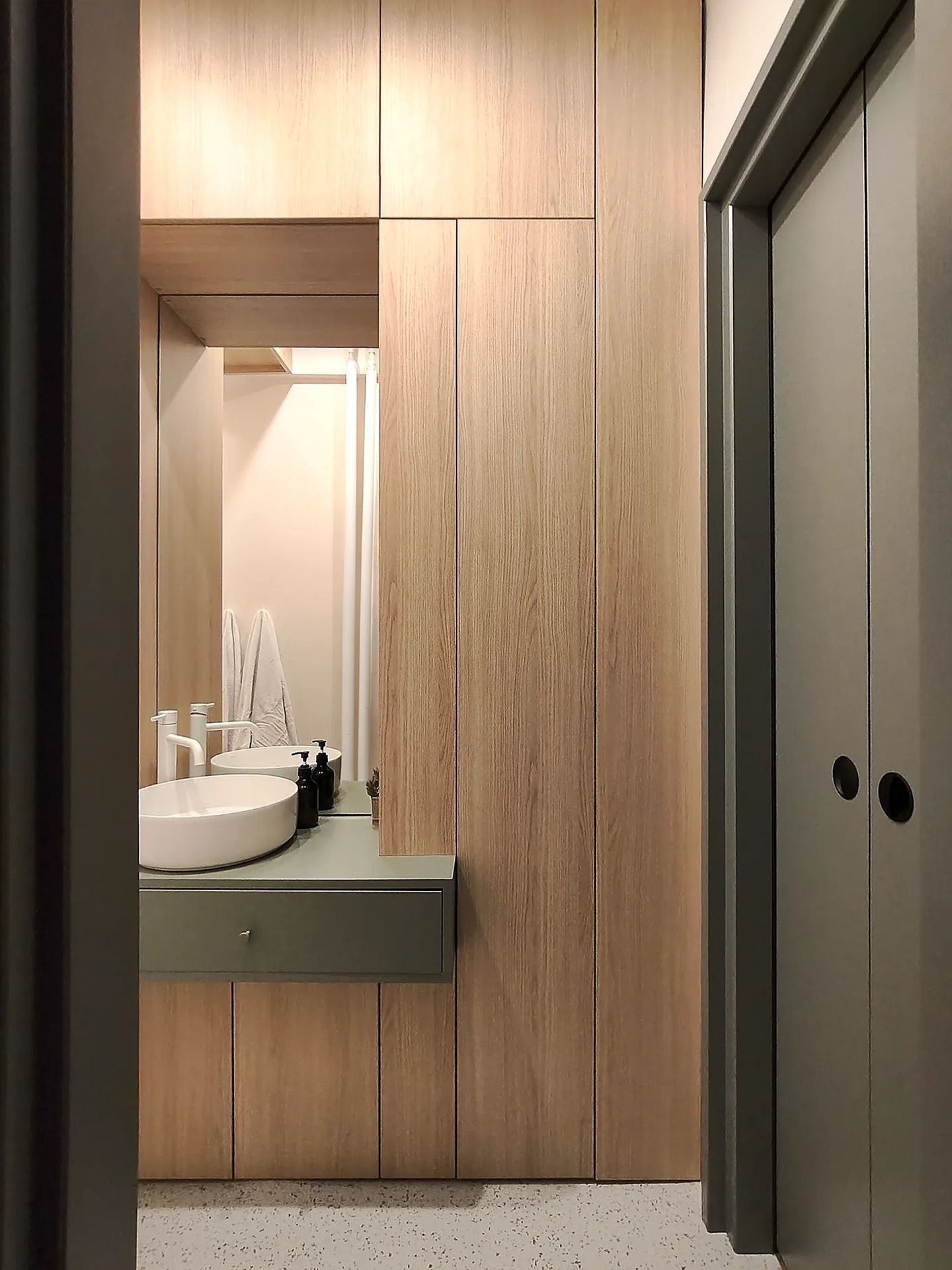 Apartament C9 — baie placată cu lemn, lavoar rotund pe blat verde suspendat și pardoseală PVC Tarkett terrazzo