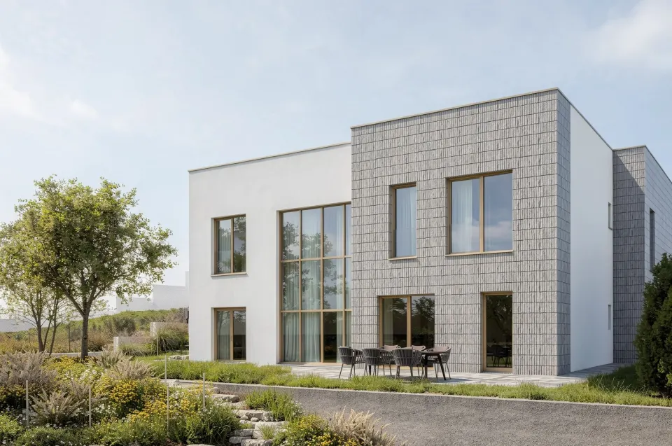 Casa MV — terasă pavată cu mobilier de exterior, între volumul placat cu cărămidă aparentă gri și aleea din pietre
